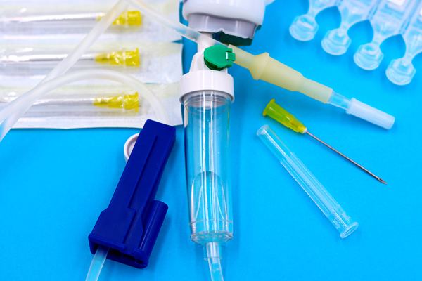 IV set, needles and ampoules on a blue surface